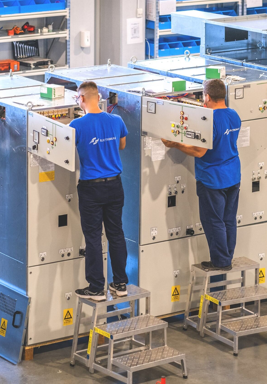 Muncitori care lucrează la echipamente electrice